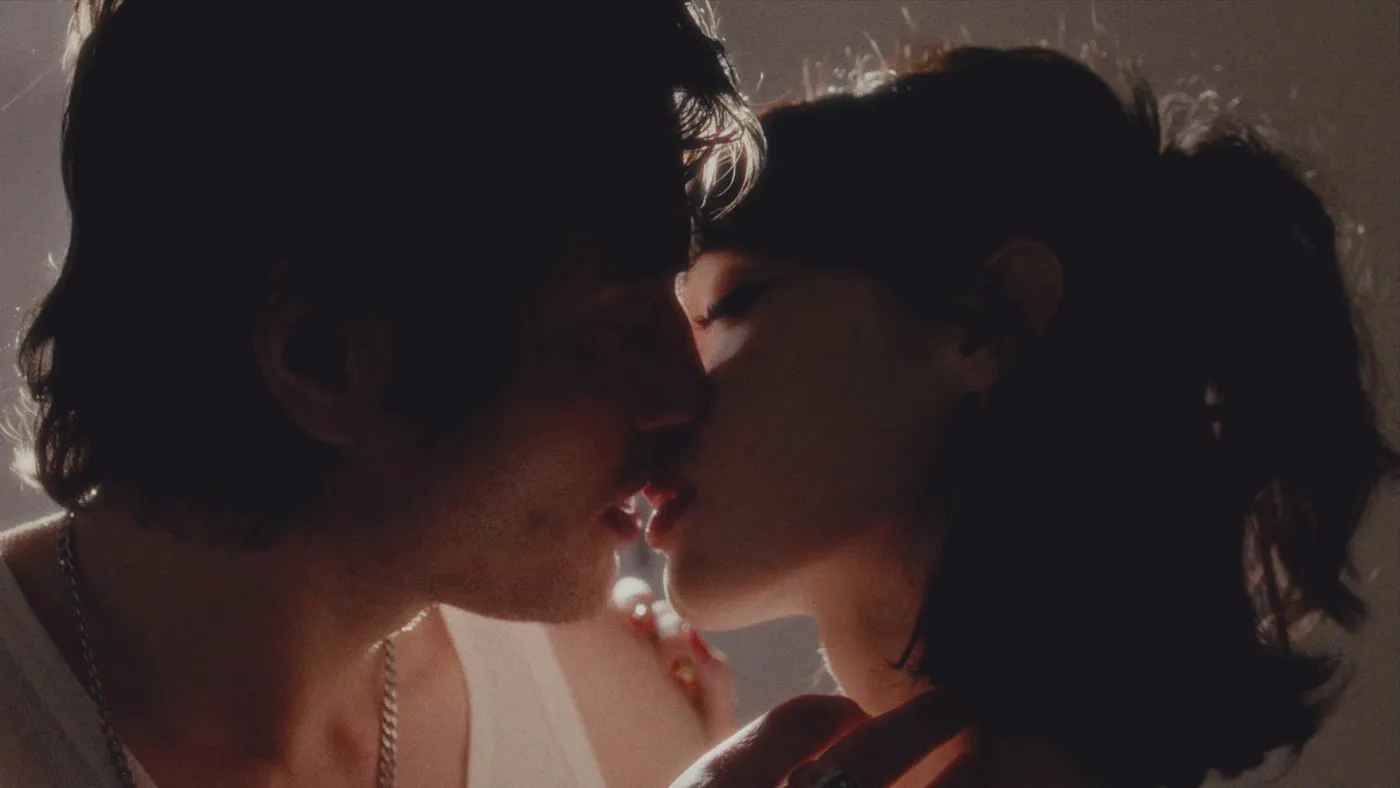 Music video still — close two-shot
